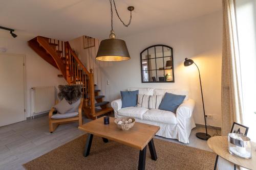 a living room with a white couch and a table at Ferienhaus Seesucht in Krummhörn