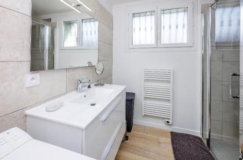 une salle de bain blanche avec un lavabo et une douche dans l'établissement Petit Appartement de Coubertin - Jardin - Calme - Albi, à Albi