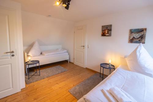 a living room with a bed and two tables at Ferienhaus Klötzlehuus in Krummhörn
