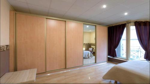 - une chambre dotée d'un grand mur d'armoires dans l'établissement Le petit Paris-Hyper centre METZ, à Metz