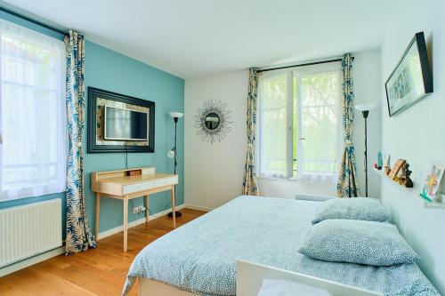 - une chambre avec des murs bleus, un lit et un bureau dans l'établissement House for 8 people, 5 min by bus to Disneyland, à Serris