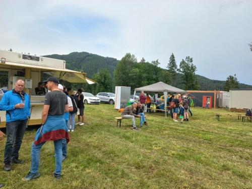 a group of people standing outside of a food truck at Campingplatz Orange Schindelbacherhof in Spielberg