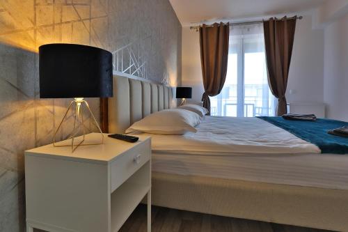una camera da letto con un letto con una lampada sul comodino di Ada Homes B4628 a Braşov