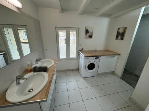 a bathroom with two sinks and a washing machine at La Maison du Chapron - Jaunay Marigny - Futuroscope in Jaunay-Marigny