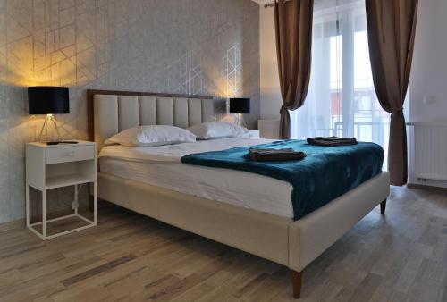 una camera da letto con un letto grande con una coperta blu di Ada Homes B4628 a Braşov