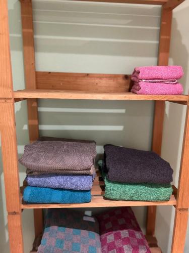 - un ensemble de serviettes assises sur une étagère en bois dans l'établissement La petite Garenne - T2 Climatisé et jardin privé, à Albi
