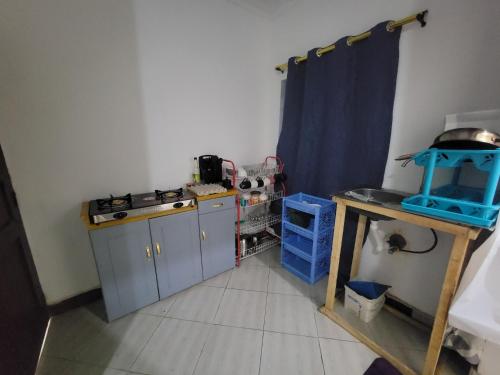 a kitchen with a sink and a stove and a table at EMMY'S HIDE AWAY in Iringa
