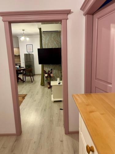 a living room with a television and a dining room at Catedrala Blue in Constanţa