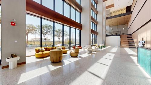 a lobby with couches and chairs in a building at The Community Jumeirah Village in Dubai