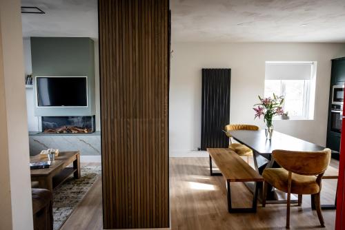 a living room with a table and chairs and a television at Felim's Place in Doolin
