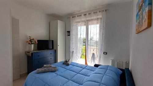 a bedroom with a blue bed and a window at Villa Rosetta in Villaggio Mosè
