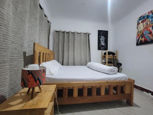 a bedroom with a wooden bed and a window at EMMY'S HIDE AWAY in Iringa