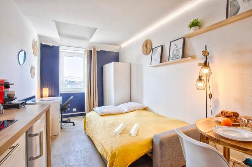 a small room with a bed and a table at Le Tilleul - Centre ville - Parking privé - Wifi in Caen