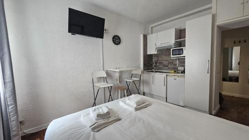 a white room with a bed and a kitchen at Estudio en Gran Via centro in Madrid