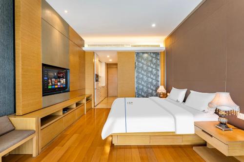 a bedroom with a large bed and a flat screen tv at eStay Residence·Poly World Trade Center Guangzhou in Guangzhou