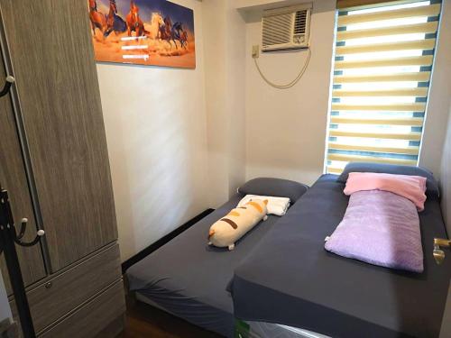 a bedroom with a bed with two pillows on it at lea home flair tower staycation mandaluyong in Manila