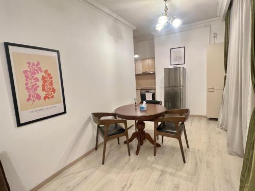 a dining room with a table and chairs and a refrigerator at Catedrala Blue in Constanţa