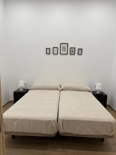 a bed in a room with three pictures on the wall at Apartamento Murcia San José C in Murcia