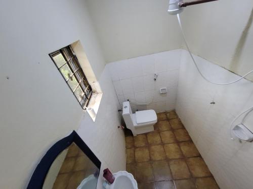 a small bathroom with a toilet and a window at EMMY'S HIDE AWAY in Iringa