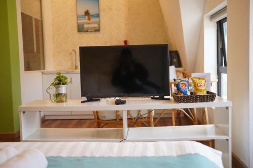 a television on a white stand in a living room at Love Hotel - Khách Sạn Theo Giờ in Da Lat