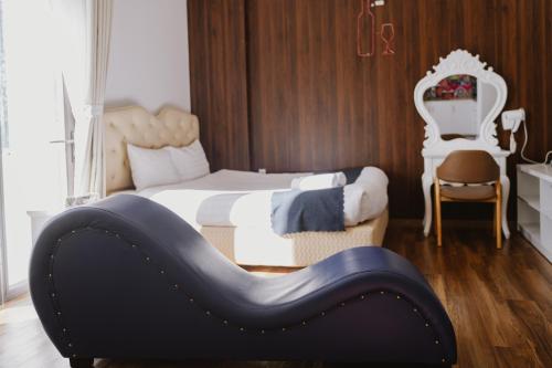 a bedroom with a bed with a black and white headboard at Love Hotel - Khách Sạn Theo Giờ in Da Lat