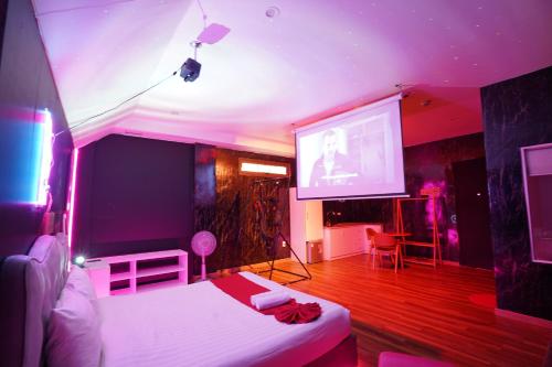 a room with a bed and a projection screen at Love Hotel - Khách Sạn Theo Giờ in Da Lat