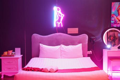 a bedroom with a bed with a neon sign above it at Love Hotel - Khách Sạn Theo Giờ in Da Lat