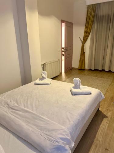 a large white bed with towels on top of it at Catedrala Blue in Constanţa