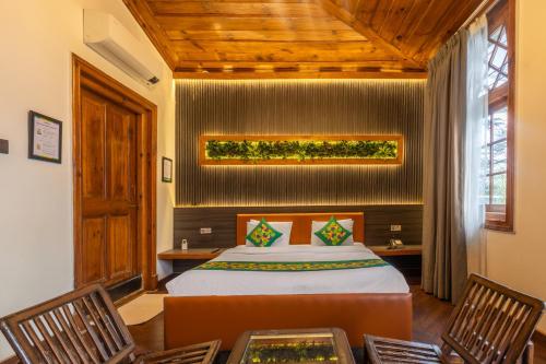 a bedroom with a bed and two chairs at Treebo Premium Torrentium - A Heritage Hotel in Shimla