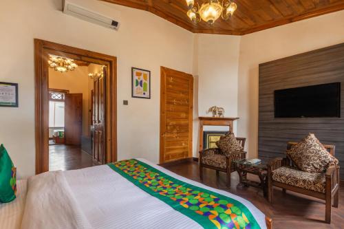 a bedroom with a bed and a flat screen tv at Treebo Premium Torrentium - A Heritage Hotel in Shimla