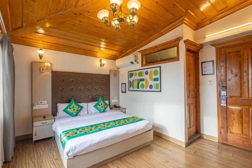 a bedroom with a large bed and a wooden ceiling at Treebo Premium Torrentium - A Heritage Hotel in Shimla