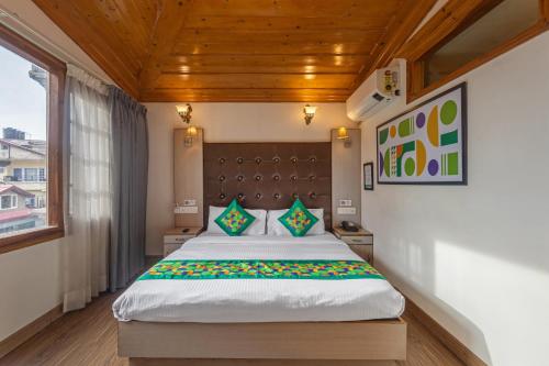 a bedroom with a large bed with a wooden ceiling at Treebo Premium Torrentium - A Heritage Hotel in Shimla