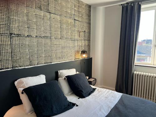 - une chambre avec un lit avec deux oreillers et une fenêtre dans l'établissement Villa Marguerite - Chambres d'Hôtes, à Saint-Omer