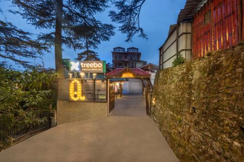 a walkway leading to a hotel with a sign on it at Treebo Premium Torrentium - A Heritage Hotel in Shimla