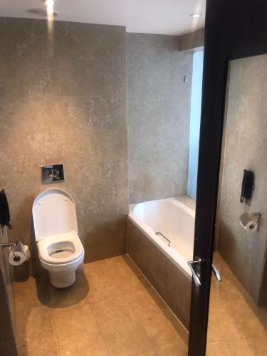a bathroom with a toilet and a bath tub at The Boma Nairobi in Nairobi