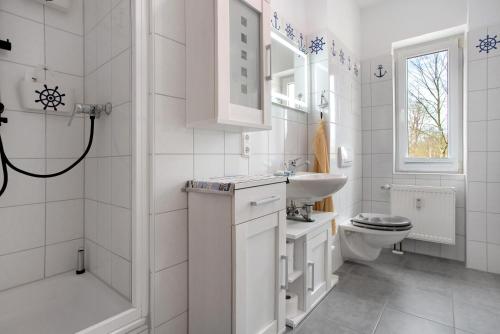 a white bathroom with a sink and a toilet at Meer-Natur-Idyll in Peenemünde