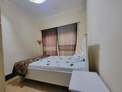 a small bedroom with a bed with a window at EMMY'S HIDE AWAY in Iringa