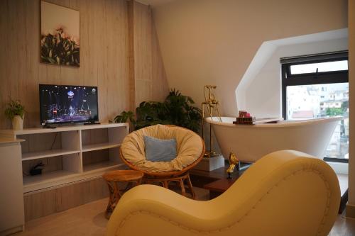 a living room with a tub and a chair at Love Hotel - Khách Sạn Theo Giờ in Da Lat