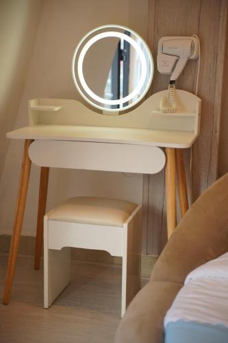 a dressing table with a mirror and a stool at Love Hotel - Khách Sạn Theo Giờ in Da Lat