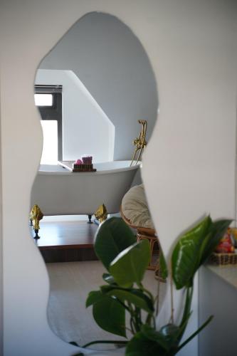 a bathroom with a tub and a plant in a mirror at Love Hotel - Khách Sạn Theo Giờ in Da Lat