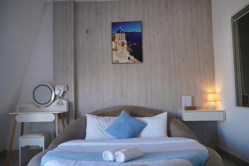 a bedroom with a bed with a blue and white pillow at Love Hotel - Khách Sạn Theo Giờ in Da Lat