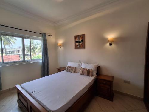 Un dormitorio con una cama grande y una ventana. en ORCHID PLACE DEVELOPMENT LIMITED, en Accra