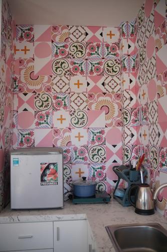a kitchen with a pink and white wall with a sink at Love Hotel - Khách Sạn Theo Giờ in Da Lat