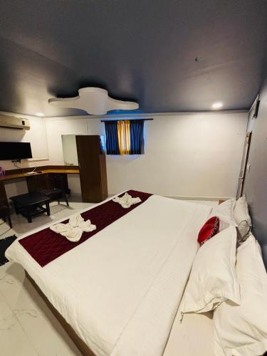 a bedroom with a large white bed with a desk at The Elite Beachview in Puducherry