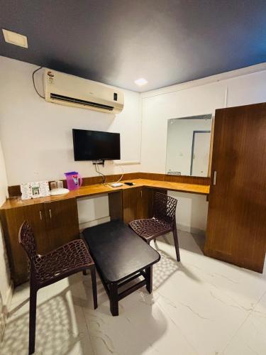 a room with a desk with two chairs and a computer at The Elite Beachview in Puducherry