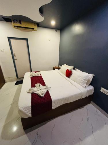 a bedroom with a bed with white sheets and red pillows at The Elite Beachview in Puducherry