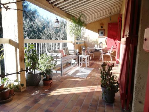 un patio avec des plantes en pot et un banc sur un patio dans l'établissement Serenity, à Seillans