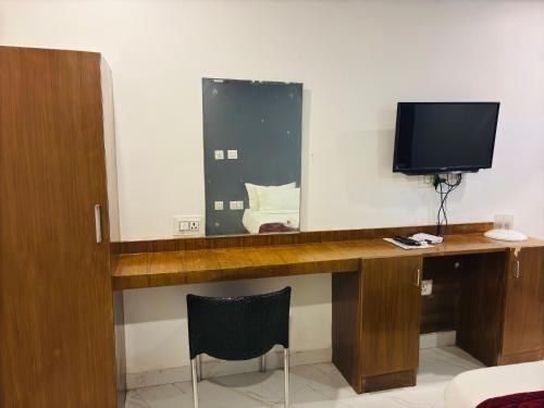 a room with a desk with a tv and a mirror at The Elite Beachview in Puducherry