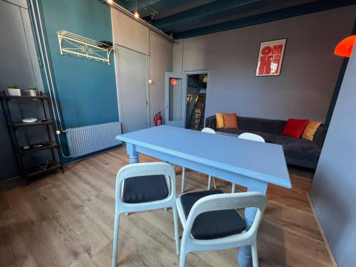 a blue table and some chairs in a room at Nes B&B in Amsterdam