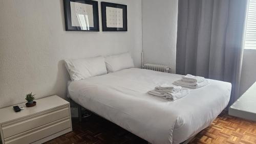 a bedroom with a white bed with towels on it at Estudio en Gran Via centro in Madrid